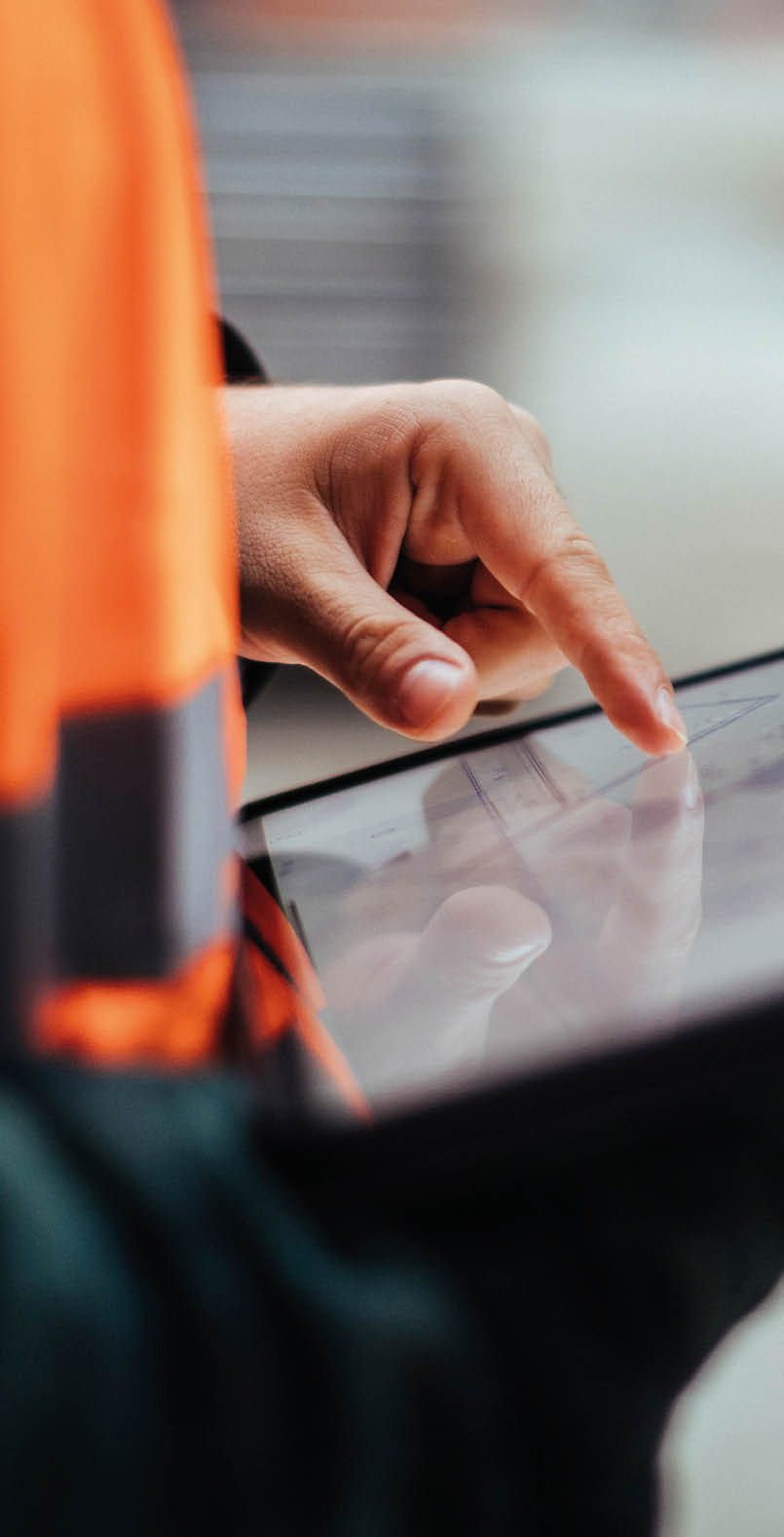 Unrecognizable construction worker hands holding a digital tablet while working outdoors