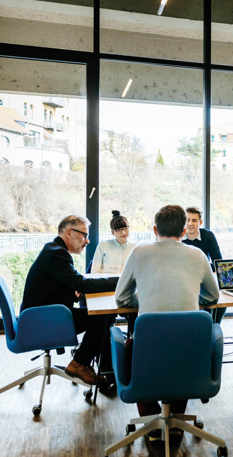 New business meeting with a group of entrepreneurs on a conference table in a modern office loft