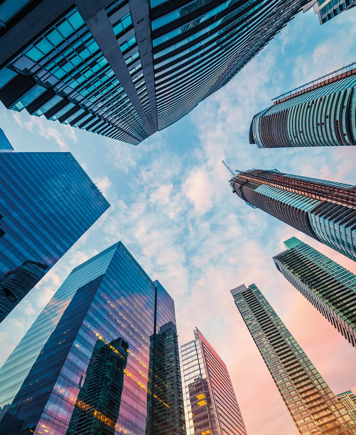 Low angle view of modern corporate skyscrapers, with modern glass windows facade and urban architectural designs in Toronto downtown during sunrise.